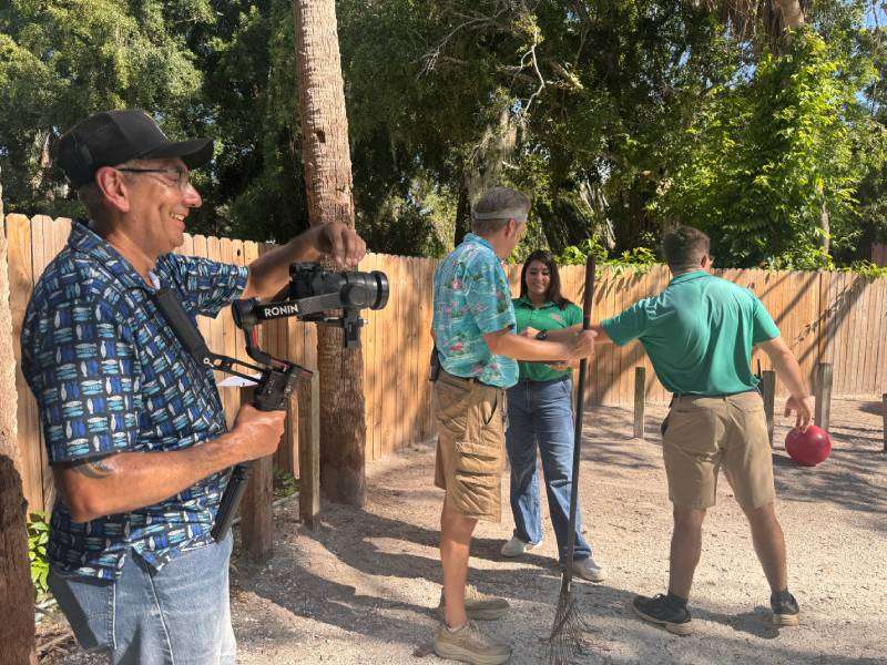 Grapevine Videographer, Felix, Filming Nichole and S.J.G. Staff cleaning animal enclosures at Sarasota Jungle Gardens.